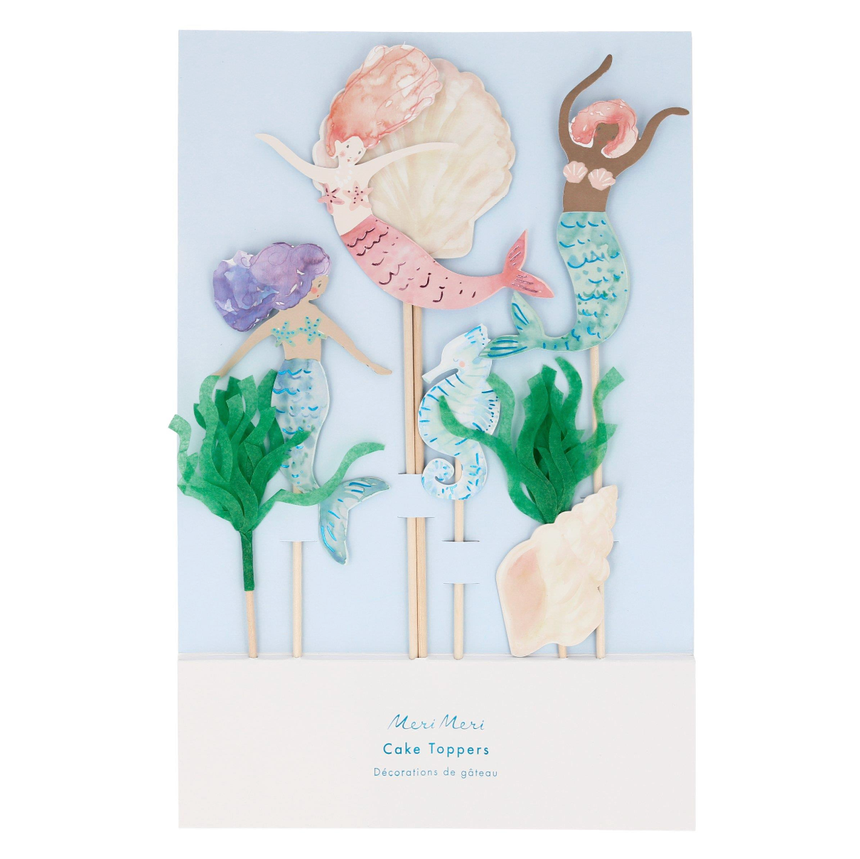 Set of mermaid-themed cake toppers with seashells and seaweed on a light blue background.